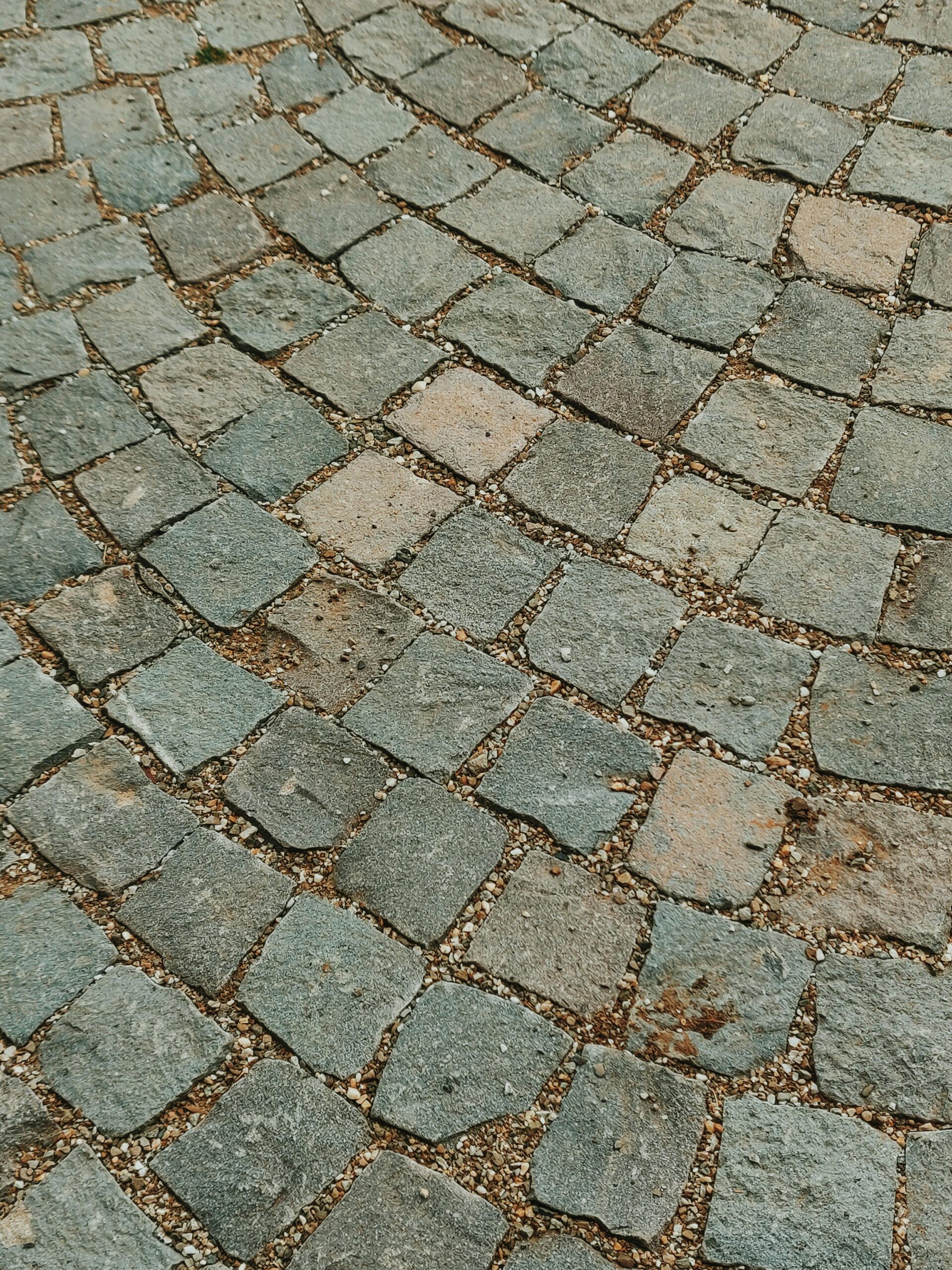 A rustic cobblestone pavement in Romania showcasing a textured, earthy surface with rough stones.